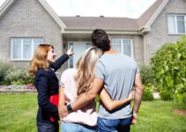 Real Estate agent woman with clients near new house.