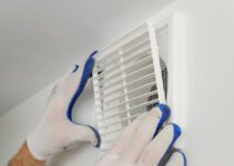 Worker installs ventilation grille.