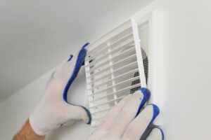 Worker installs ventilation grille.