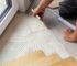 Worker laying parquet flooring. Worker installing wooden laminate flooring