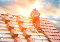 Roofer working on roof structure of building on construction site