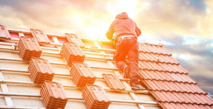 Roofer working on roof structure of building on construction site